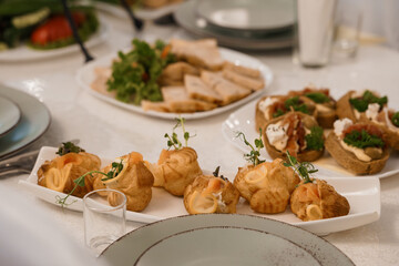 Elegant Buffet Spread with Smoked Salmon Croquettes, Toasted Bread Tarts, and Fresh Greens on White Tablecloth