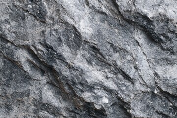 Textured natural stone surface with gray and black shades featuring distinct folds and cracks, showcasing interesting relief and rugged beauty for architectural and design projects
