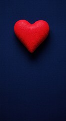 Obraz premium Textured scarlet red heart decoration resting on a deep indigo blue textile backdrop, suitable for love, romance, or greeting cards ,ornament, red, symbol