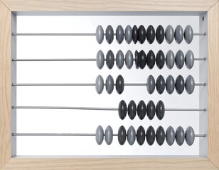 Close-up of an abacus with grey, black, and neutral-toned beads on silver rods, framed in a light wood
