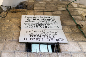 A multi-lingual sign in arabic, english, and hebrew for a dentist's office, 