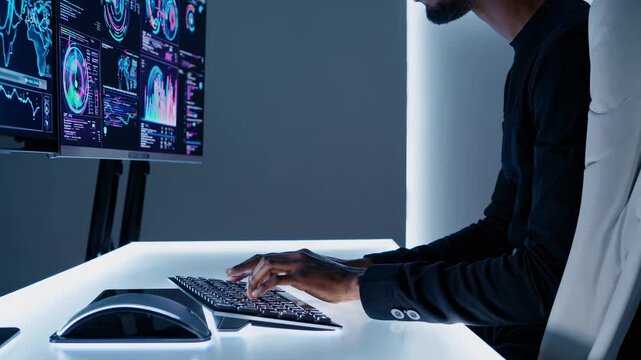 Side angle of a person at a sleek desk, analyzing data on multiple screens. The futuristic setup suggests a tech-focused video theme.