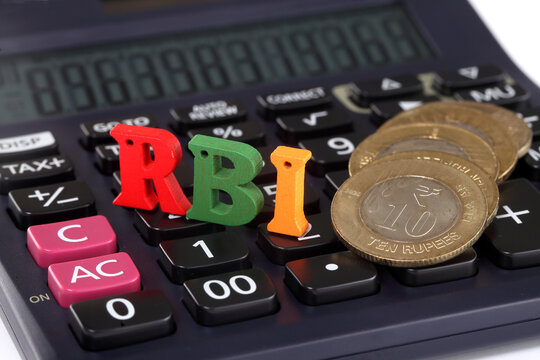 RBI letters on stack of coins and calculator