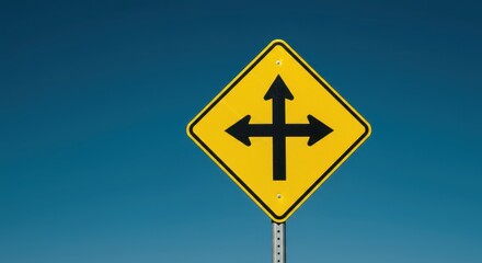 A bright yellow diamond-shaped warning sign indicating a four-way intersection ahead, crucial for traffic safety and driver awareness on the highway system, street, caution, road
