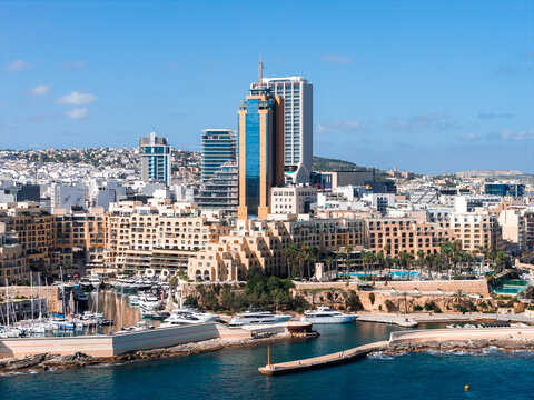 Aerial daytime view of Sliema and St. Julian's, Malta, with Portomaso Marina, yachts, breakwaters, and the Portomaso Business Tower beside modern high rises.