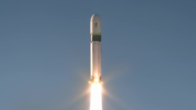 Orbital launch vehicle lifting off from spaceport, engines blazing with bright exhaust and billowing smoke, ascending through clear blue sky to deliver satellite payload toward orbit