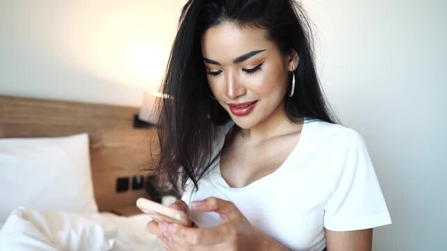 Beautiful Asian Woman Looking at Smartphone With Smile, Close Up