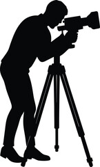 Silhouette of a cameraman operating a video camera on a tripod
