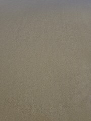 texture of sand. 
Wet sand on a deserted beach after a storm