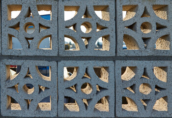 Openwork concrete fence featuring geometric patterns, showcasing a blend of light and shadow, creating a unique visual texture, ideal for backgrounds and architectural design concepts with copy space
