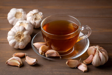 Cup of healthy garlic tea on table