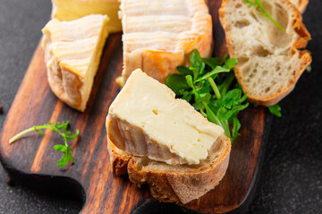 Washed rind cheese soft cheese with orange rind munster french cheese tasty snack fresh delicious gourmet food background on the table rustic top view copy space