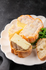 Washed rind cheese soft cheese with orange rind munster french cheese tasty snack fresh delicious gourmet food background on the table rustic top view copy space