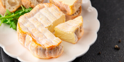 Washed rind cheese soft cheese with orange rind munster french cheese tasty snack fresh delicious gourmet food background on the table rustic top view copy space