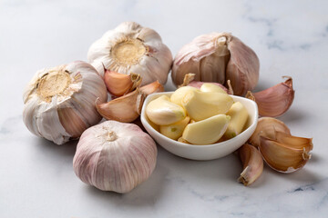 Fototapeta premium Bulbs and cloves of fresh garlic on table, closeup