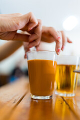 Woman swirl gently Thai milk tea in glass, signature local beverage