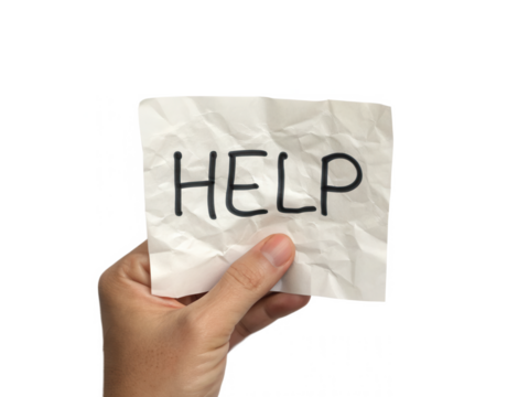 A hand holds a crumpled note with the word "HELP" prominently written on it.