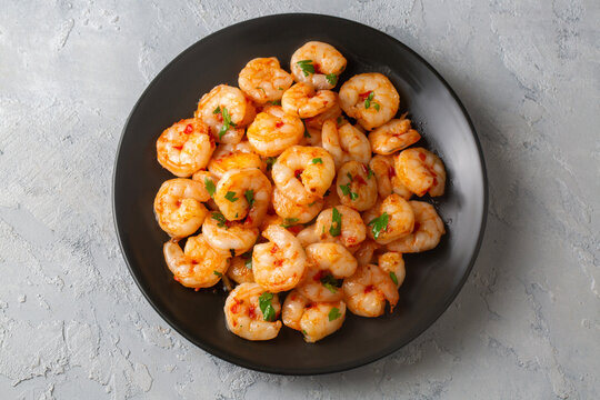Delicious seafood grilled prawns - Prawns in garlic butter sauce with lemon and parsley sprinkled in a frying pan