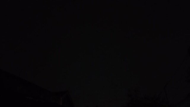 Dramatic Horizontal Lightning Bolt Flashing Across a Dark Stormy Night Sky with Visible Power Lines, Signifying Storm and Electric Power