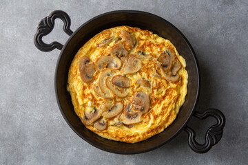Frittata is an Italian type of omelet. Omelet with mushrooms cast-iron pan.