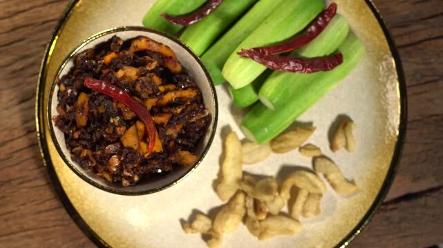Pork Crackling Chili Paste (Nam Phrik kak Moo): Crispy, spicy, and savory. This Thai relish features crunchy cracklings, chili, and herbs. Served with fresh cucumber. A perfect crunch with hot rice.