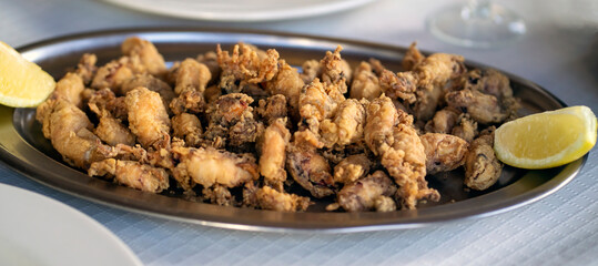 A plate with fried small delicious cuttlefish, grilled seafood closeup.