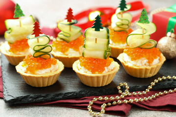 Tasty tartlets on grey textured table, closeup. Christmas appetizer