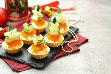 Tasty tartlets on grey textured table, closeup with space for text. Christmas appetizer