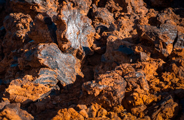 Lava formations, stones, black basalt in the rocks closeup on a volcano terrain.