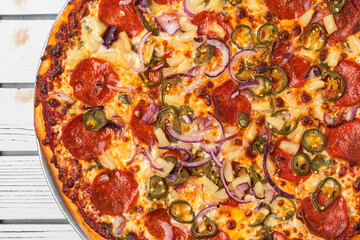 Hawaiian-style pizza featuring pepperoni, pineapple, red onion, and jalapeño slices