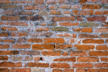 Textured brick wall with shades of orange and gray in a rustic setting