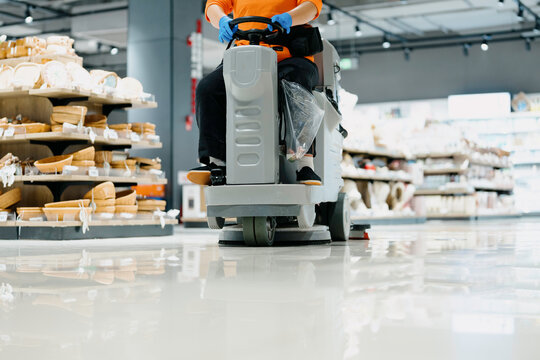 worker is cleaning floor with machine