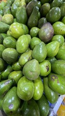 Fresh Green Avocados Piled in Market Display with Bright Lighting and Natural Colors
