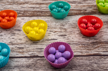 Educational Montessori board with colorful wooden balls and cups for preschool children. Creative sensory game improving fine motor skills and color recognition through play.