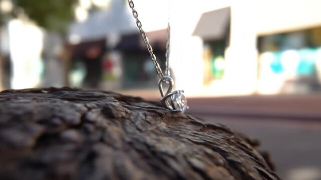 Sparkling diamond pendant necklace on textured wood surface with natural light and bokeh background