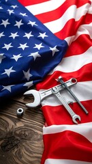 American flag backdrop with tools and fasteners on a wooden surface, overhead view