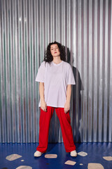 fashionable woman stands confidently against artistic studio background with sleek styling