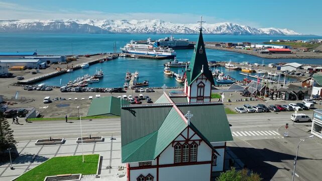 Aerial footage of Husavik&rsquo;s historic church and town centre. The coastline and distant snow-capped mountains complete the scenic view.