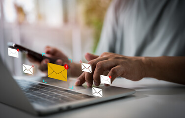 A Businessman using mobile phone, laptop open email with sign reminder for unread emails for notification and taps on a new inbox email notification icon, newsletter. Technology digital online network