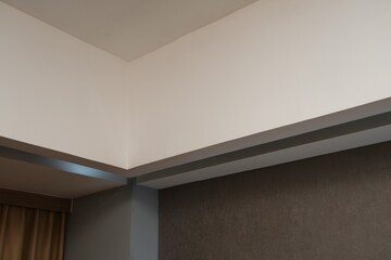 Fototapeta premium Minimalist corner of a modern room showcasing clean ceiling lines, neutral colors, and simple architectural design for interior concepts. 
