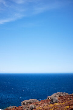 Exploring wild Spanish nature: blue sunny sky hovering over endless surface of Atlantic Ocean, view from hill