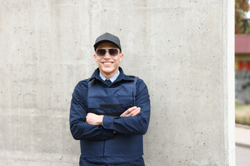 Naklejka premium Portrait of smiling police officer on city street. Space for text