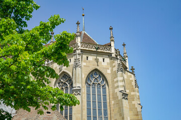 A bright stone Gothic church, photographed from a low angle The church is located in the city of Bern Switzerland The sky is blue and clear