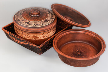 Different red clay baking crockery on a gray background