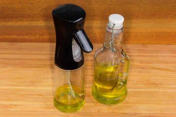 Сooking oil sprayer and small glass bottle of olive oil