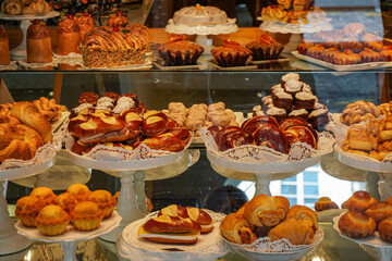 A bakery display case with a variety of pastries and cakes