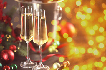 Sparkling wine in glasses and festive decor, bokeh lights. New Year greeting card