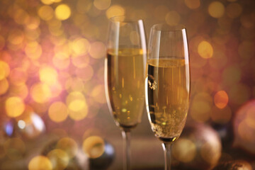 Sparkling wine in glasses, bokeh lights. New Year greeting card