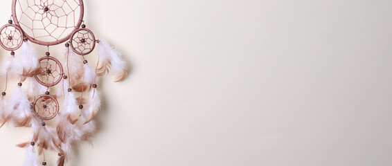 Dream catcher with feathers on beige background. Banner design