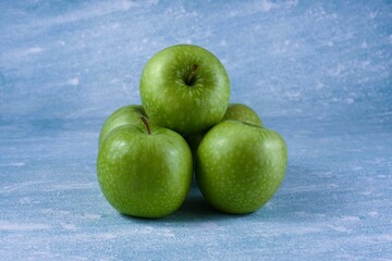 Image of five granny smith apples.